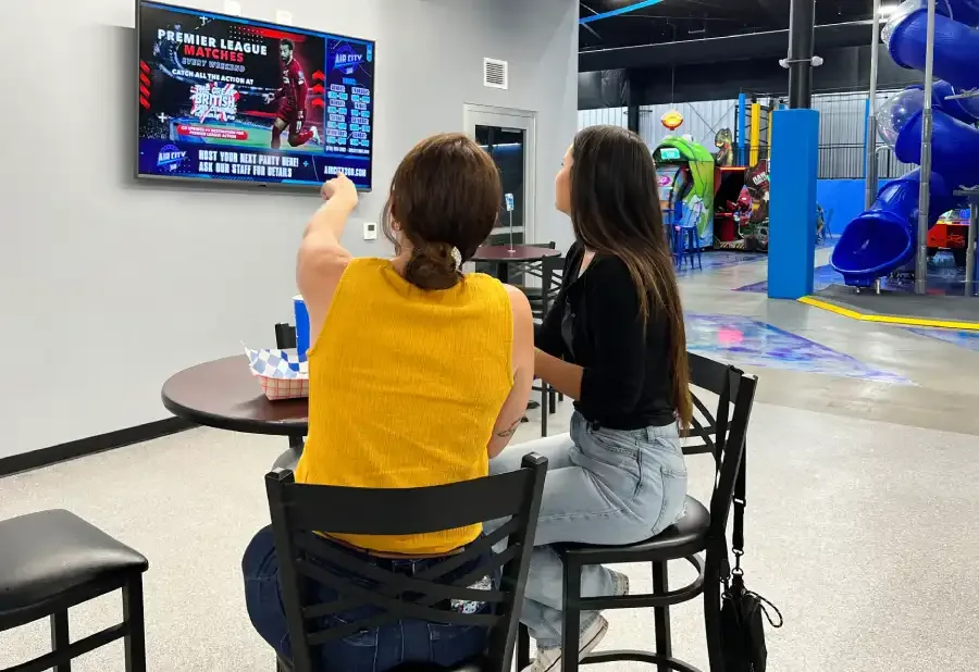 People watching a digital billboard inside a family entertainment venue